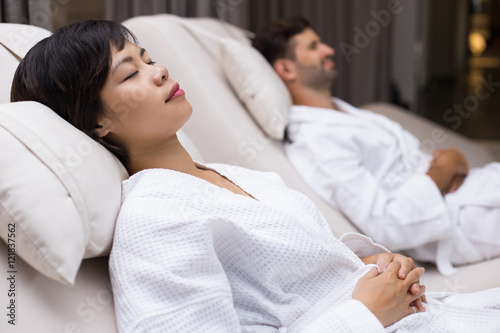 Canvas Print Dozing woman and man lying on deckchairs in spa
