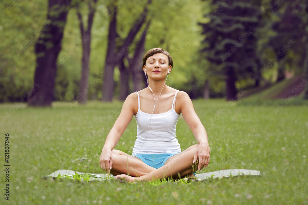 Woman with earphones relax in nature park. Woman with earphones relax in nature park.