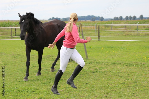 woman playing with her horse on the field