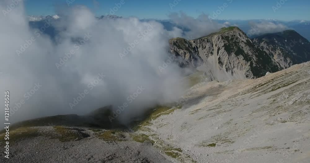AERIAL: Flying over mountain valley towards clouds. AERIAL: Flying over mountain valley towards clouds.