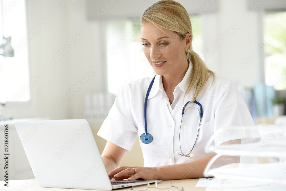Portrait of doctor in office working on laptop Portrait of doctor in office working on laptop