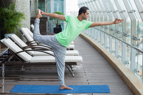 Young Man Doing Shiva Dancing Pose in Fitness Club photo