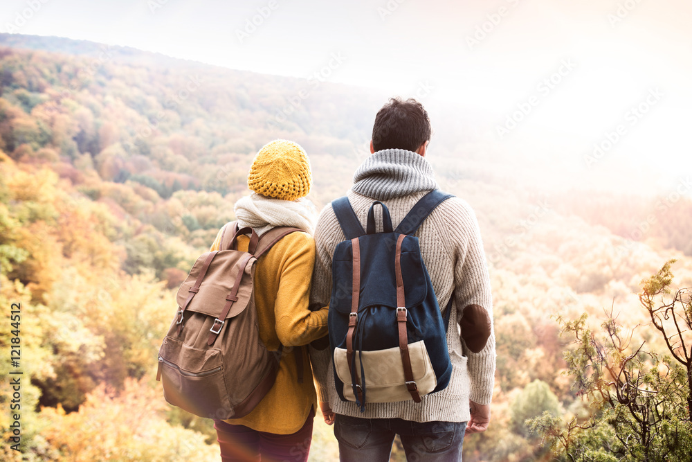Beautiful couple in autumn nature against colorful autumn forest