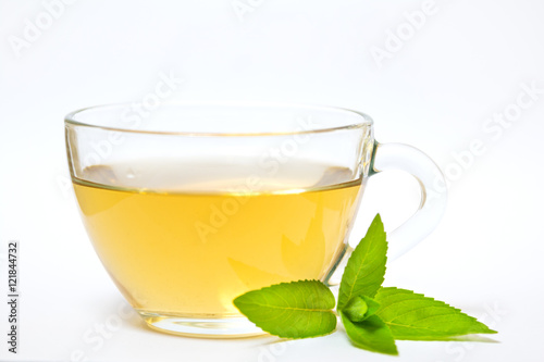 Glass transparent cup with tea and green mint leaf