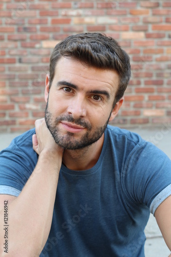 Closeup portrait of handsome young with a beard thinking deeply with finger on temple  looking at you. Human face expressionss, emotions, feelings, attitude