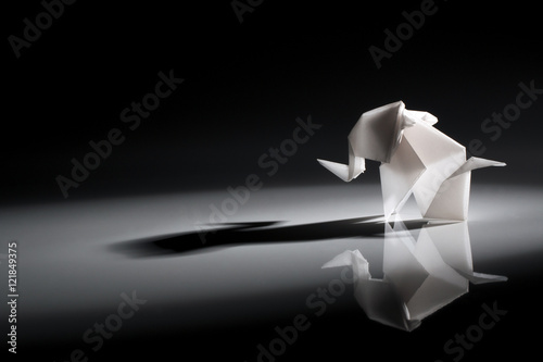 Cute origami art, colored shapes object isolated over a black background photo