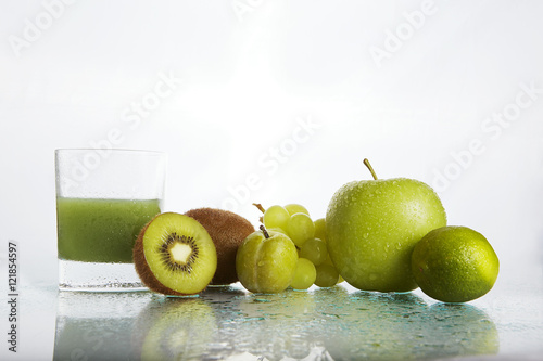 green fruits and juice on white background photo