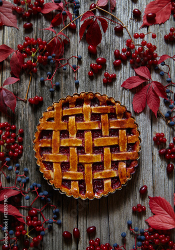 Traditional raspberry pie tart cake sweet baked pastry food on rustic wooden table background. Autumn composition decoration.