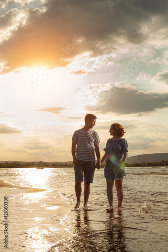 Happy couple is walking on the beach.