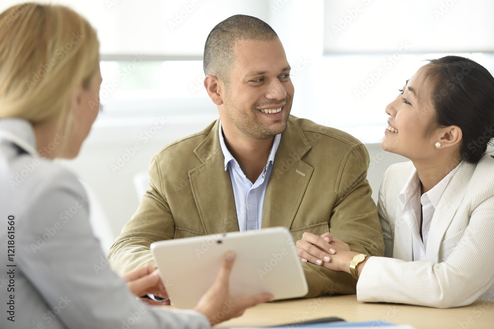 Cheerful married couple meeting financial adviser