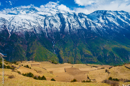 Landscape Snow Mountains Nature Viewpoint.Mountain Trekking Landscapes Background. Nobody photo.Asia Travel Horizontal picture. Sunlights White Clouds Blue Sky. Himalayas Hills Empty Fields.