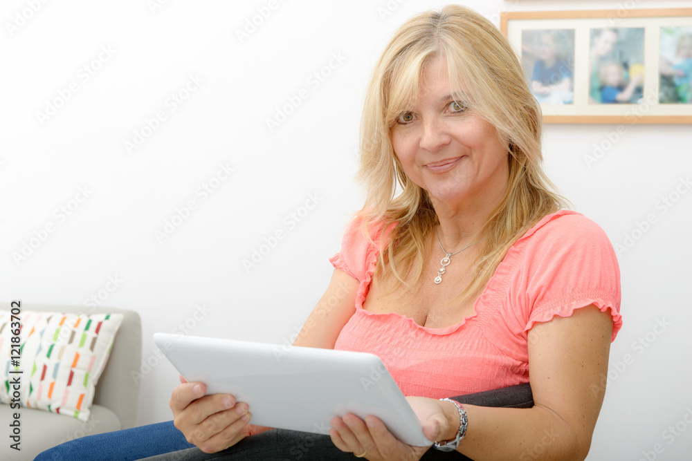 Beautiful mature woman using electronic tablet at home Beautiful mature woman using electronic tablet at home