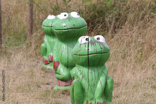 wooden green frogs in a line