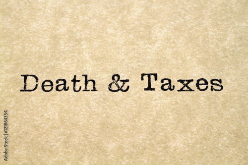 A close up image of the word "death & taxes" from a typewriter on antique paper