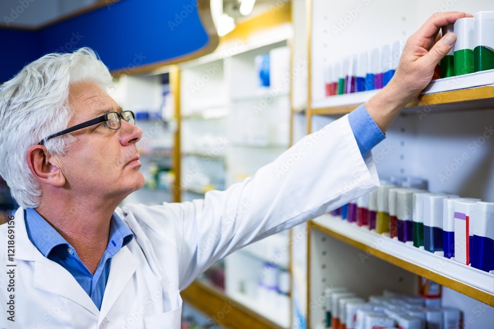 Pharmacist checking medicines in pharmacy Pharmacist checking medicines in pharmacy