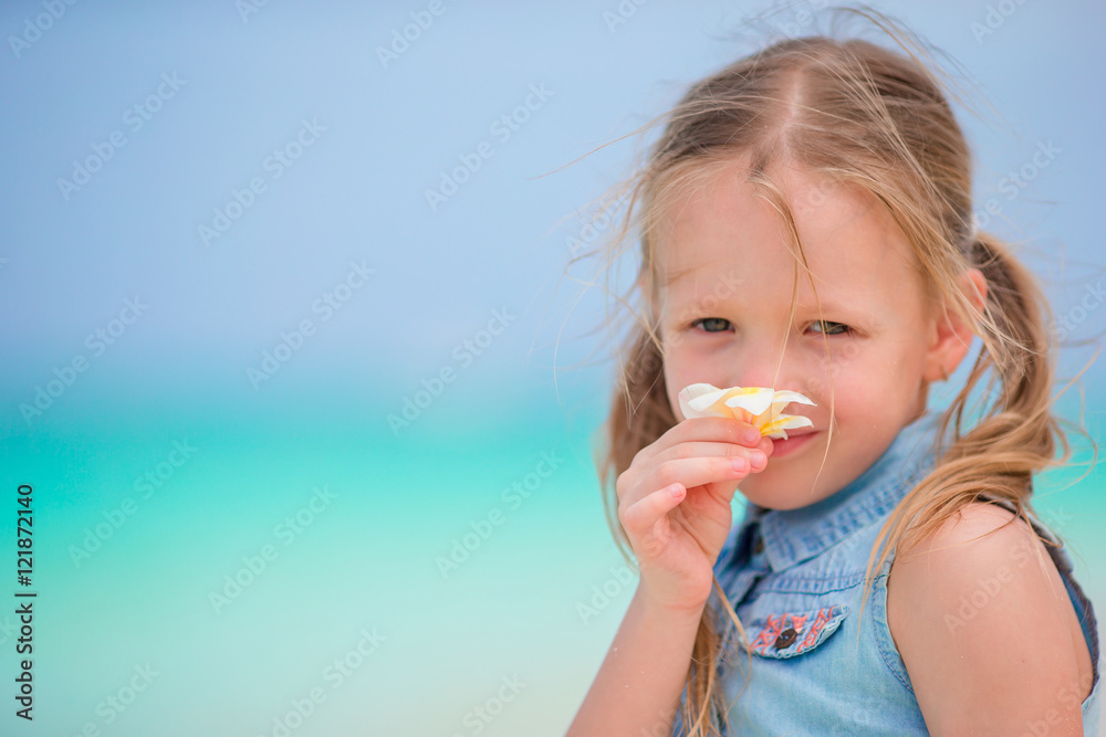 Portrait of adorable little girl with flower frangipani on beach summer vacation Portrait of adorable little girl with flower frangipani on beach summer vacation