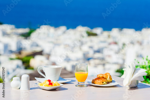 Breakfast served table by the sea. Perfect luxury breakfast table outdoors. Amazing caldera view on Mykonos, Greece, Europe.