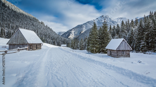 Wooden cottages covered by snow in winter at sunrise, Tatra Mountains, Poland © shaiith