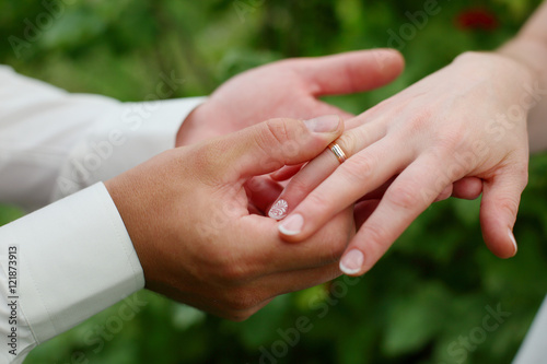 hands of the groom put the ring on the bride © oksnemova