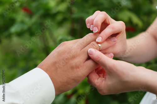 hands of the bride  put the ring on the groom © oksnemova