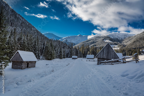 Wooden cabins covered with snow in winter at sunset, Tatra Mountains, Poland