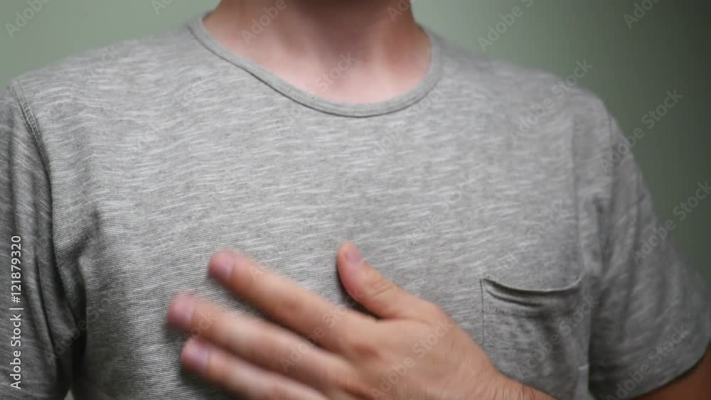 Man rubbing his chest with the palm of his hand because of the intense