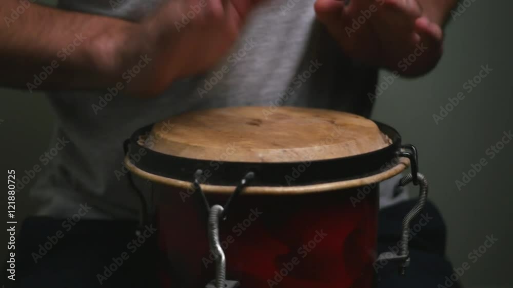 Playing a small bongo with two hands. Playing a small bongo with two hands.