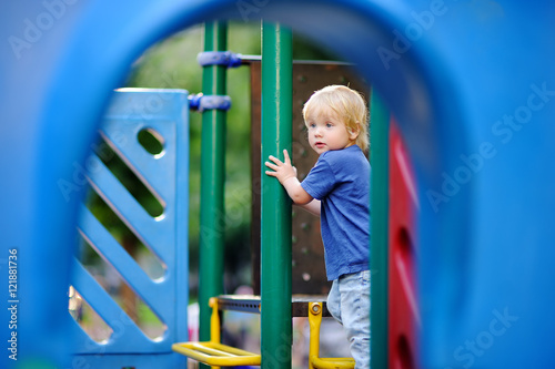 Cute toddler boy having fun on outdoors playground