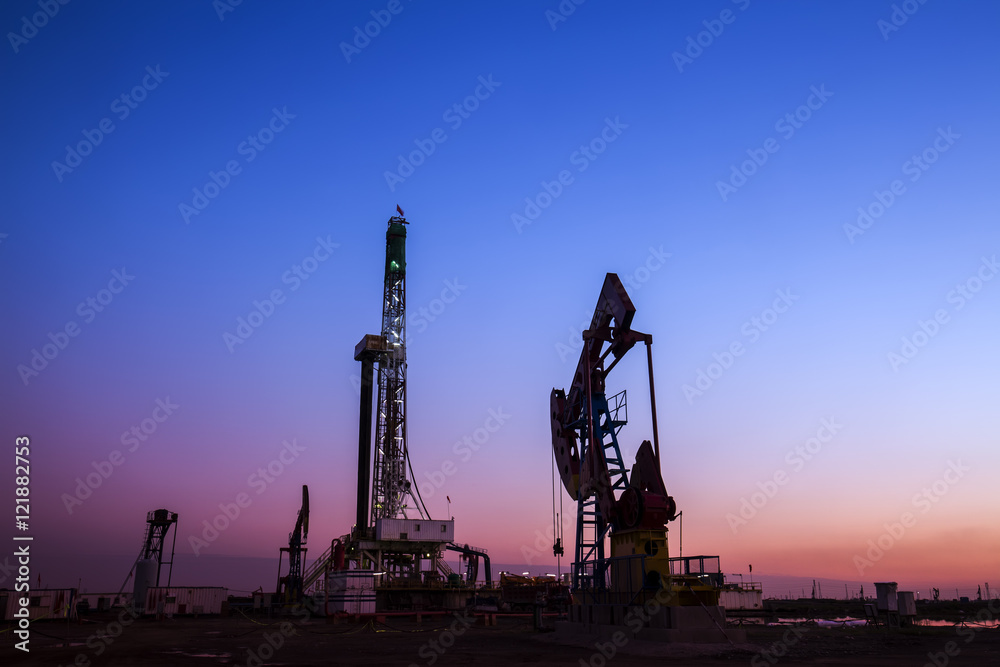 Oil field scene, the evening of beam pumping unit in silhouette Oil field scene, the evening of beam pumping unit in silhouette