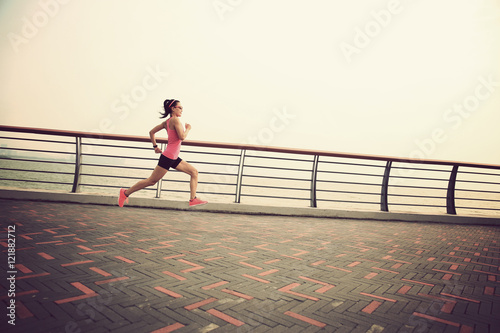 young fitness woman running at seaside