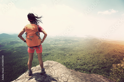 successful woman hiker enjoy the view at mountain peak
