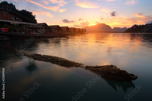 Silhouette scenery during sunrise of houseboat resort at lake river in natural attractions,Ratchaprapha Dam at Khao Sok National Park,Surat Thani Province in Thailand.Traveling , recreation Concept