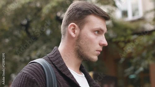 attractive young man with serious gaze looking into the camera: 4k footage