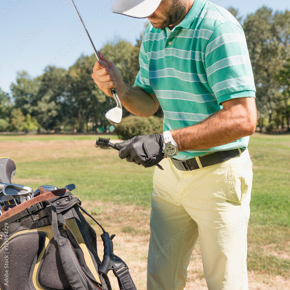 Fototapeta premium Golf. Golfer cleaning his club