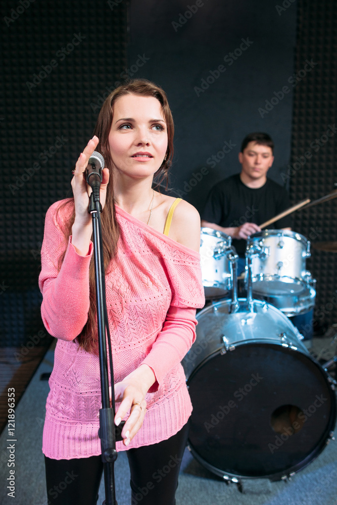 Fototapeta premium Female singer on stage holding microphone. Woman soloist ready to sing a song, music band performance. Hobby, pastime, show, leisure concept