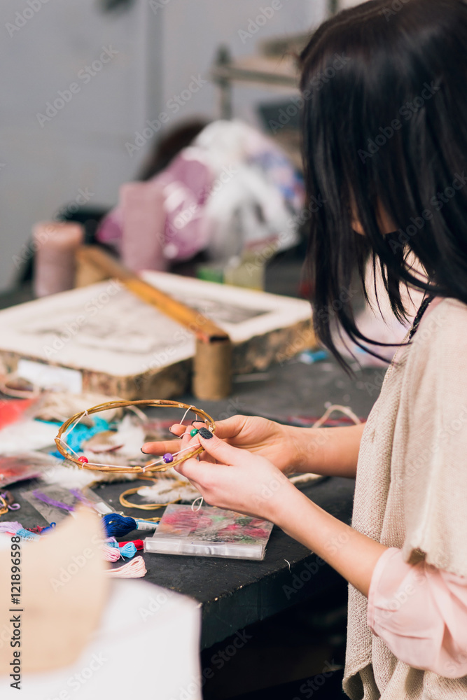 Art studio with creating dream catcher artisan. Unrecognizable woman weaving wooden circles for house decoration. Creativity, handicraft, hobby concept Art studio with creating dream catcher artisan. Unrecognizable woman weaving wooden circles for house decoration. Creativity, handicraft, hobby concept