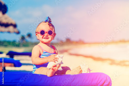 cute little baby girl with seashells on tropical beach © nadezhda1906