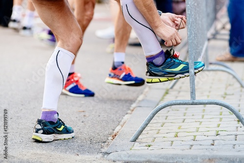 Man ties his sport running shoe before the race.