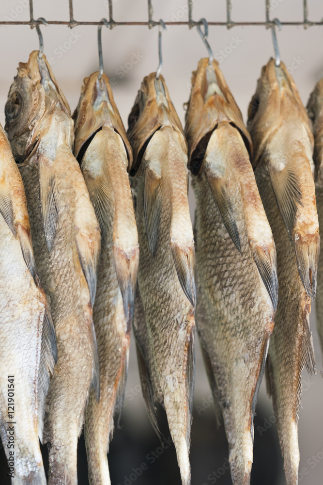 Fototapeta premium Dried fishes on the hooks, background