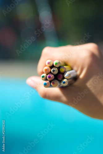 Colorful pencils with hand holding