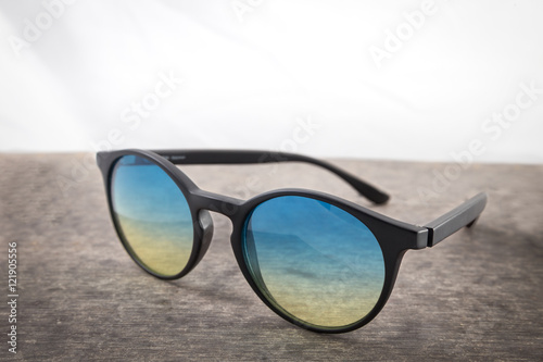 blue and yellow sunglasses on a wooden background close up