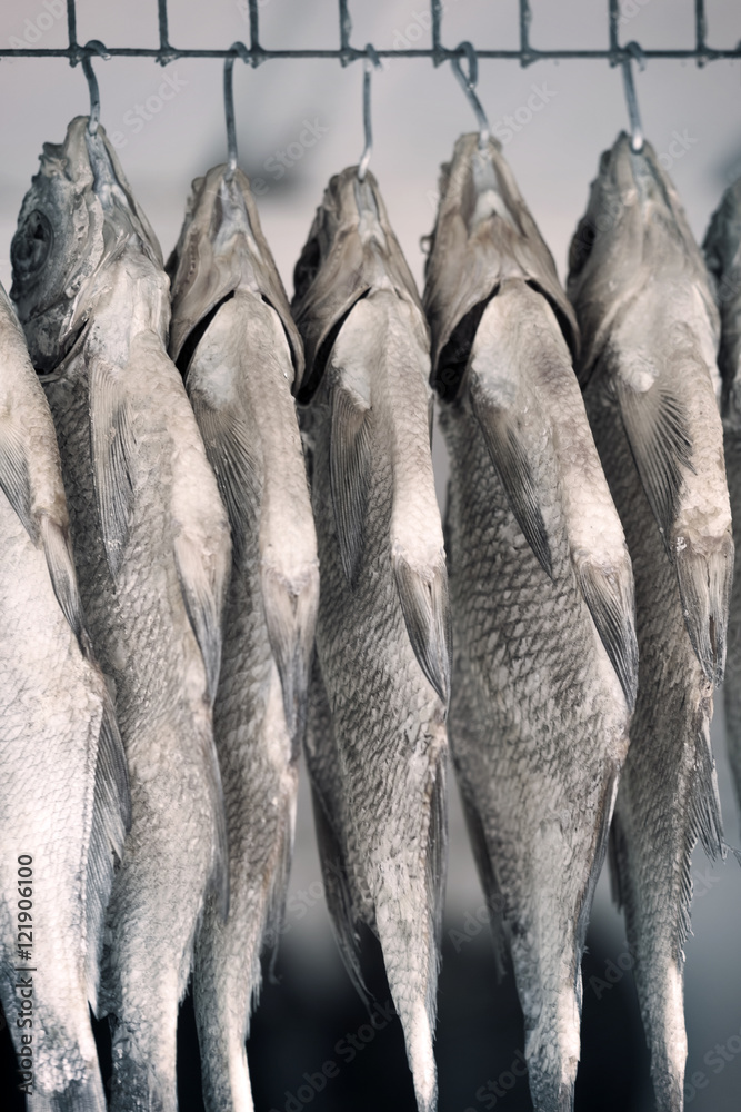 Obraz premium Dried fishes on the hooks, background