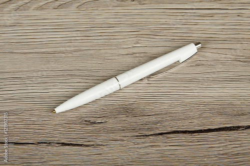 White pen on a wooden background.