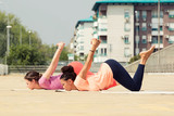 Beautiful women doing yoga outdoors in an urban neighbourhood