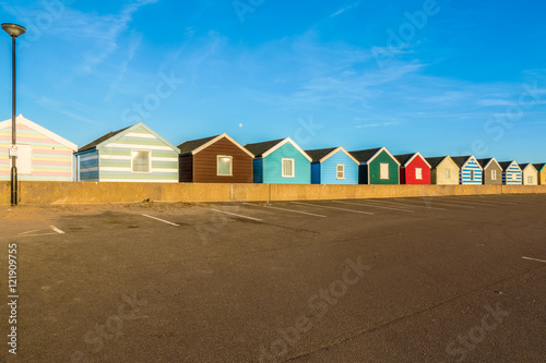 Row of colourful beach huts against a blue sky in Southwold, Suffolk, UK photo