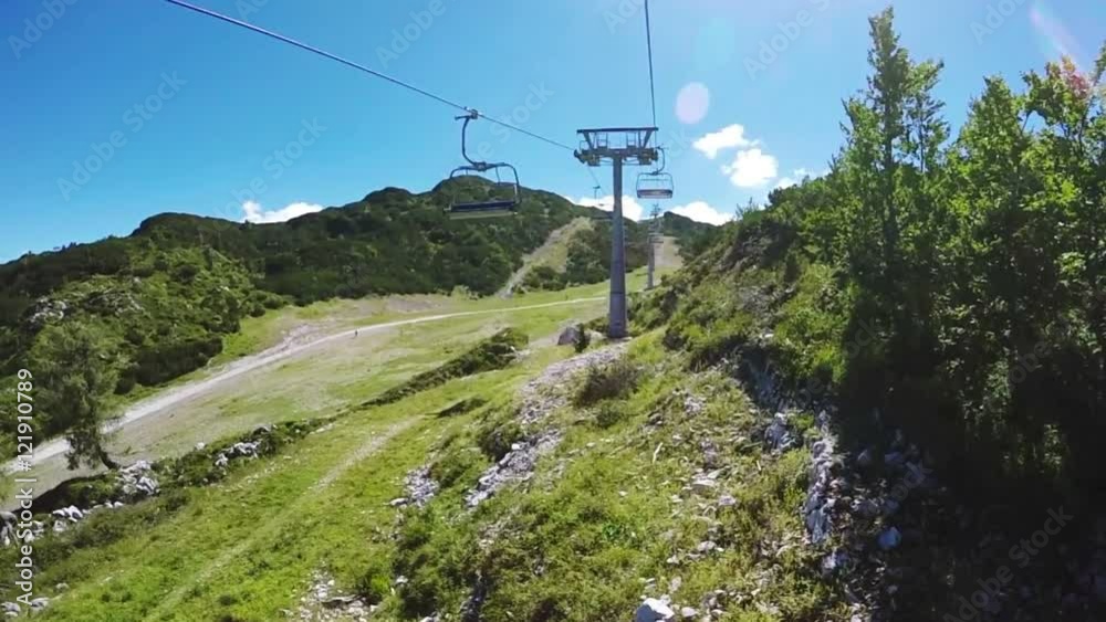 Chairlift cable hoist ride on bright summer day, Vogel mountain in Slovenian national park Triglav