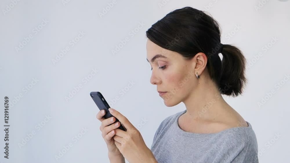 Young beautiful woman writes an SMS to her mobile phone Young beautiful woman writes an SMS to her mobile phone