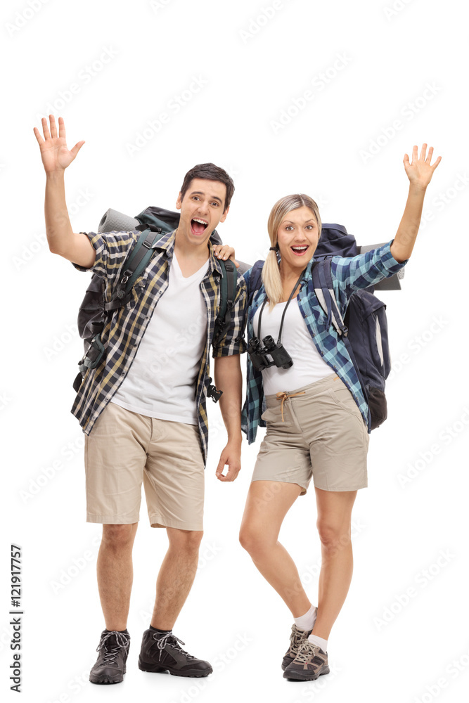 Two happy hikers waving at camera