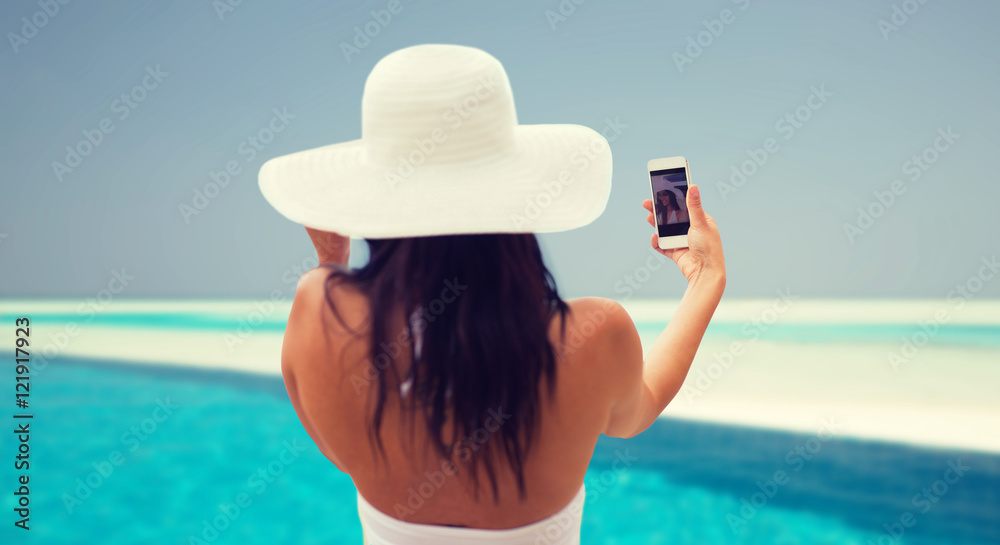 smiling young woman taking selfie with smartphone