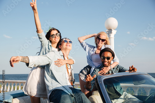 Cheerful young friends sitting and relaxing in car
